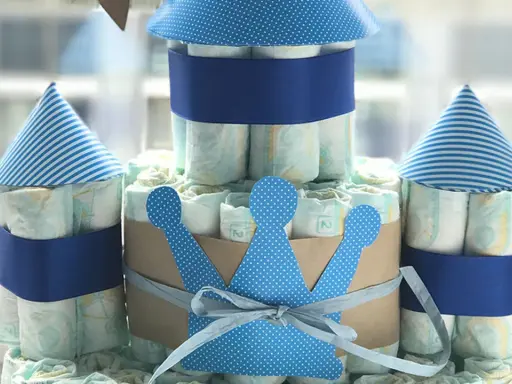 Eine Windeltorte als Schloss, mit blauen Türmen und einer Krone. So kann man eine Windeltorte selber machen!