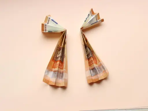 Zwei gefaltete 50-Euro-Scheine bilden Flügel, die an Geldengel falten anleitungen erinnern.