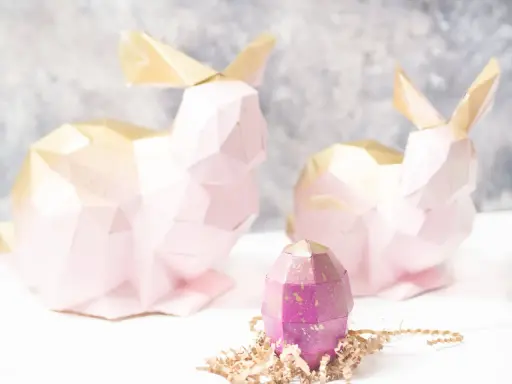 Zwei rosa 3D Origami Hasen mit goldenen Ohren und ein lila Ei. Eine Anleitung für 3d origami hase anleitung wäre hier toll.