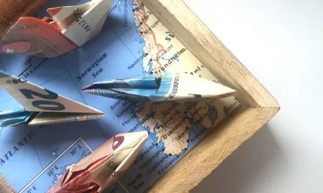 Kreative **Geldscheine falten** zu Schiffen, die auf einer Karte der norwegischen See segeln. Eine **muschel**-förmige Faltung ist nicht zu sehen, aber die Origami-Boote sind detailreich.