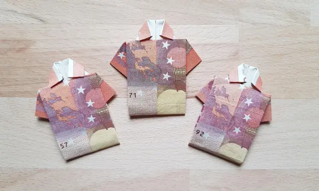Drei Origami-Hemden aus Geldscheinen. Das letzte Hemd falten ist eine Kunst für sich.