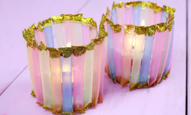 Zwei bunte Windlichter, die Kinder mit Papier und Glitzer basteln können. Sie leuchten sanft.