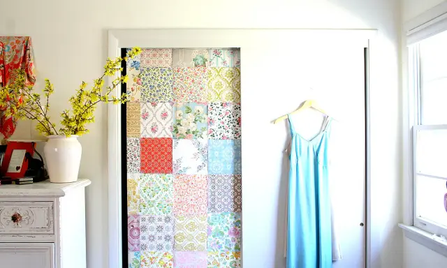 Kreatives Basteln mit Tapetenresten: Ein Patchwork-Muster ziert die Tür eines Schranks. Daneben hängt ein hellblaues Kleid.