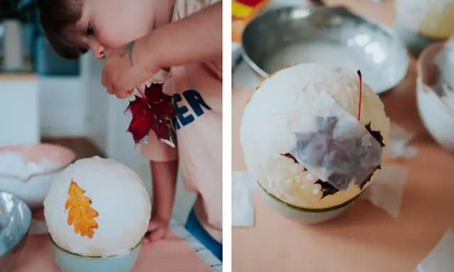 Kind bastelt eine Laterne: Luftballon, Kleister und Herbstblätter werden zu einem Kunstwerk.