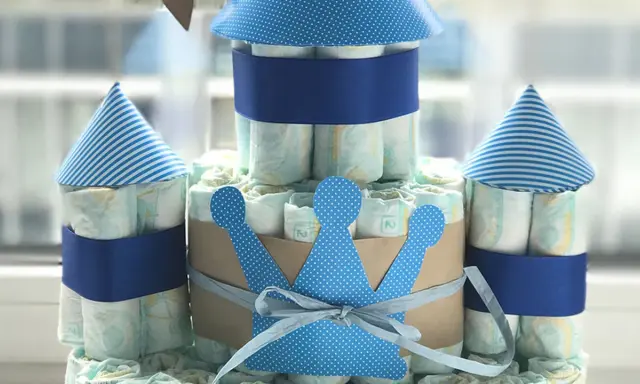 Eine Windeltorte als Schloss, mit blauen Türmen und einer Krone. So kann man eine Windeltorte selber machen!