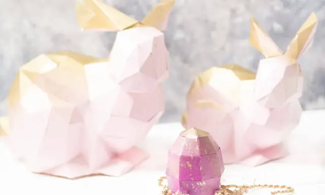 Zwei rosa 3D Origami Hasen mit goldenen Ohren und ein lila Ei. Eine Anleitung für 3d origami hase anleitung wäre hier toll.