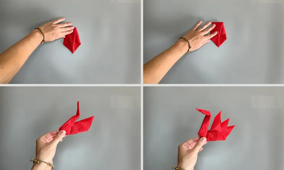 Schritt-für-Schritt-Anleitung: Servietten falten Schwan. Eine Hand formt eine rote Serviette zu einem eleganten Schwan.