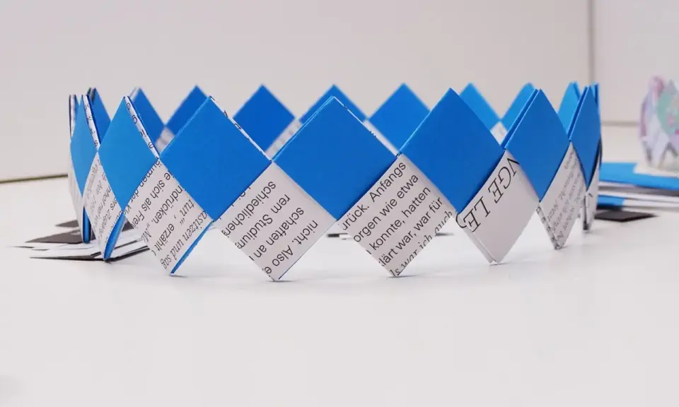 Eine selbstgebastelte Geburtstagskrone aus Papierstreifen, blau und weiß, mit Text bedruckt. Perfekt zum Geburtstagskrone basteln!