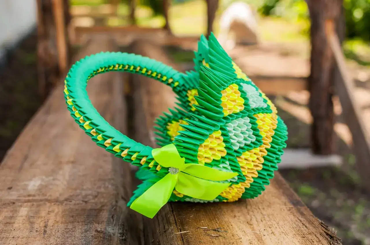 Gr&uuml;ne und gelbe 3D-Origami-K&ouml;rbchen mit Schleife, perfekt f&uuml;r eine Bastelanleitung.